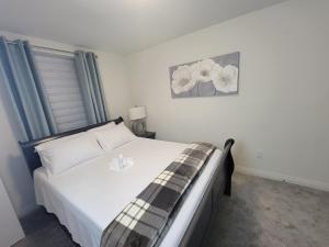 PenetanguisheneChorburjo Cozy Villa - Deluxe Room的一间卧室配有一张铺有白色床单和鲜花的床。