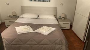 孔韦尔萨诺Dimora maria的一间卧室配有一张带两条白色毛巾的床