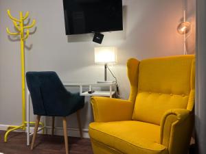 维尔纽斯Stay Vilnius Hotel的客厅配有黄色椅子和灯