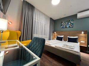 维尔纽斯Stay Vilnius Hotel的配有一张床和一把椅子的酒店客房