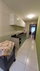 安格拉杜斯雷斯Apart Angra dos Reis I的厨房配有绿色橱柜和白色瓷砖地板。