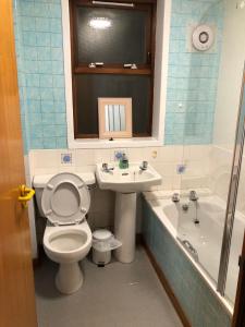 ScallowayCosy flat, Scalloway的浴室配有卫生间、盥洗盆和浴缸。