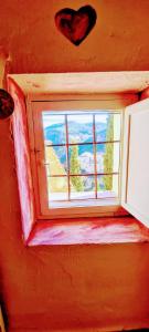 昆卡La Ronda的墙上有心的红色房间的窗户