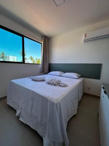 塔曼达雷Beira-mar Tamandaré / Carneiros的一间卧室配有一张带白色床单的床和一扇窗户。