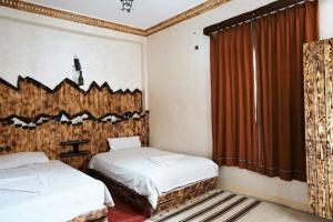 廷吉尔Dounia Hostel的一间卧室设有两张床和窗户。