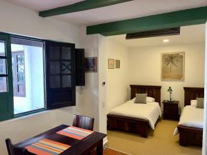 波哥大Casa Aranjuez的一间卧室设有两张床、一张桌子和一个窗口
