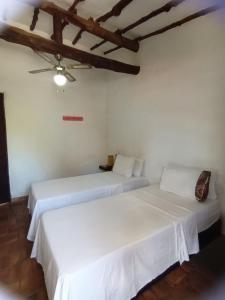 巴里查拉Casona CHARA的配有2张床的白色墙壁和天花板