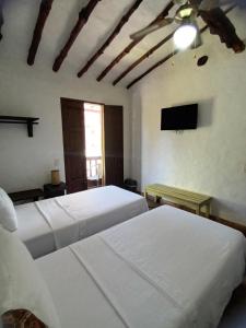 巴里查拉Casona CHARA的一间卧室配有两张床和一台平面电视