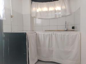 莱瓦镇ABI HAPPY的厨房配有带白色窗帘的桌子和窗户。