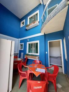 TamoiosNacif&Alcantara Suítes的一间设有红色椅子和蓝色墙壁的餐厅
