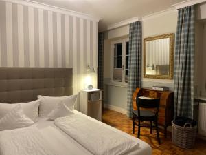 斯图林根施瓦恩宾馆的一间卧室配有一张床、一张书桌和一面镜子