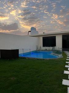 利雅德HAFAL Resort شاليهات هافال的一座白色的建筑,在院子里设有游泳池