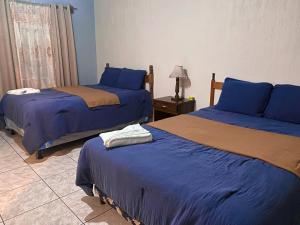 科万Hotel Xucaneb的一间卧室设有两张床和一张桌子上的台灯。