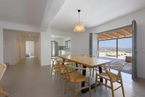 MármaraAegean Gem Villa with private pool in Paros的厨房以及带木桌和椅子的用餐室。
