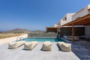 MármaraAegean Gem Villa with private pool in Paros的一个带白色椅子的游泳池以及一座房子