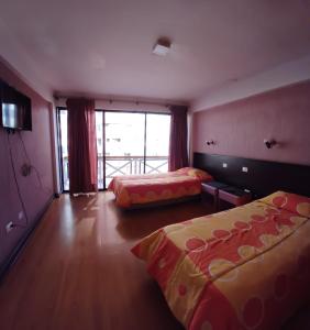 伊基克Hotel Charlie Inn的酒店客房设有两张床和一个阳台。