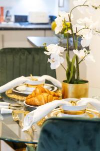 布罗姆利Preciousluxurysuit的一张桌子,上面放着一盘羊角面包和白色的鲜花
