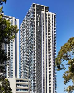 悉尼车士活美利通公寓式酒店的一座高大的建筑,上面有阿瓦隆字