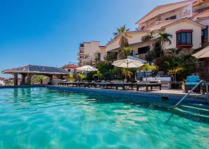 卡波圣卢卡斯Marina View Villas的度假村的游泳池,配有桌子和遮阳伞