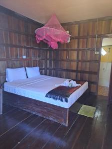 东德岛Riverside Bungalow Don Det的卧室配有木墙内的一张床
