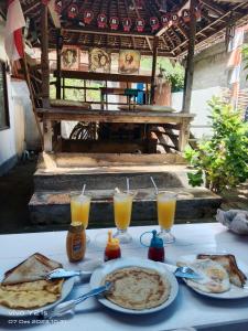 吉利特拉旺安fullesguesthouse的餐桌,带食物盘和橙汁杯
