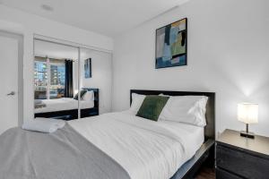 多伦多Cityplace Luxury suites的白色的卧室设有一张大床和一个窗户