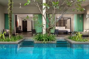苏林海滩Twinpalms Phuket的酒店游泳池的背景是一间卧室