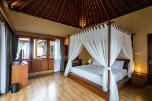 姆杜克Shankara Munduk Bali的一间卧室配有一张带天蓬的床
