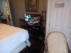 温莎WaterfrontHome-RiverView, Windsor ,Canada的一间卧室配有一张床和一张桌子上的电视