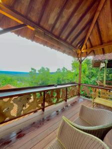 班图尔拉贾克拉纳度假酒店和Spa中心的木制甲板上摆放着椅子和桌子