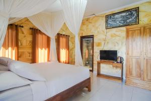 BalianMejan Home Stay的卧室配有白色的床和电视。