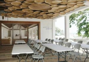 LonggaNaya Matahora Island Resort的一间设有白色桌椅和天花板的客房