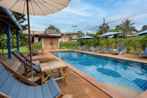 高兰穆克兰达生态度假酒店的游泳池旁配有椅子和遮阳伞