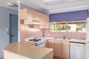 彩虹海滩Rainbow Sands Resort的厨房配有白色炉灶和水槽