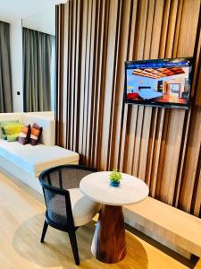 纳仲天朵沙达海洋度假村的客厅配有桌子、沙发和电视。