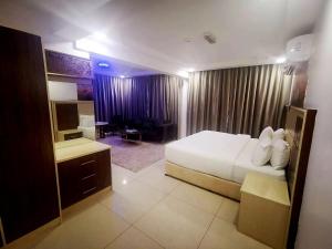 锡卜Diamond Star Hotel فندق النجمة الماسية的酒店客房设有一张大床和一张书桌。