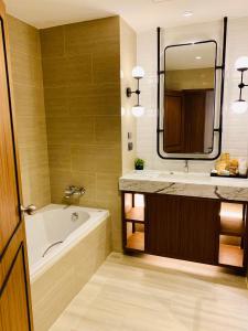 纳仲天朵沙达海洋度假村的带浴缸、水槽和镜子的浴室