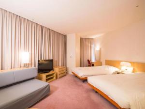 汤泽町苗场王子大饭店的酒店客房设有两张床和一台平面电视。