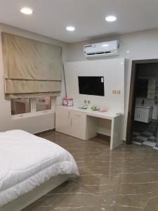 索哈尔Marina Town的一间卧室配有一张床、一张书桌和一台电视。