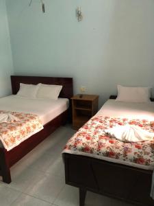 美奈红地旅馆的一间卧室设有两张床和床头柜