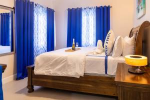 卢西Welcome to our Ocean View Villa!的一间卧室配有蓝色窗帘的床