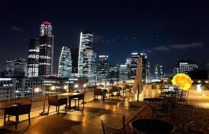首尔GLAD Yeouido的享有城市天际线的夜间美景,配有桌椅