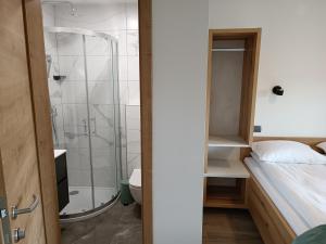 博希尼Apartmaji Hodak的带淋浴的浴室和客房内的一张床