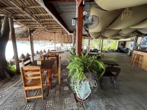 班泰Apsara & Dragon’s Supra Wellness Resort的一间设有桌椅的餐厅,以及一间种植了植物的餐厅