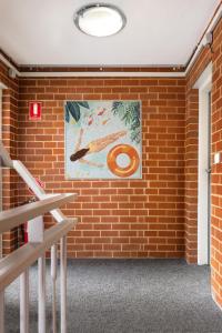 墨尔本MAC St Kilda by Melbourne Apartment Collection的墙上挂着一幅画的砖墙