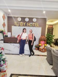 永隆RUBY HOTEL Vĩnh Long的两名妇女站在旅馆前