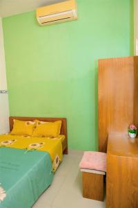 芽庄LUCKY HOME的一间卧室设有一张床和绿色的墙壁
