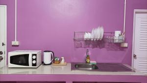 甲米镇您好公寓的紫色的厨房配有水槽和微波炉