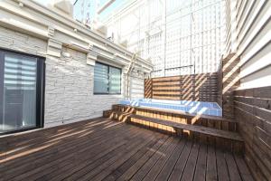 釜山HOUND HOTEL sasang branch的阳台设有木凳和建筑