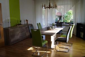 弗里茨拉尔Ferienwohnung am Eckerich的厨房配有木桌和绿色椅子